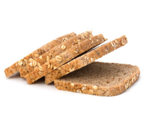 Healthy bran bread slices with rolled oats isolated on white background