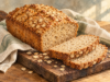 Angeschnittenes Haferbrot mit Haferflockenkruste auf einem Holzbrett